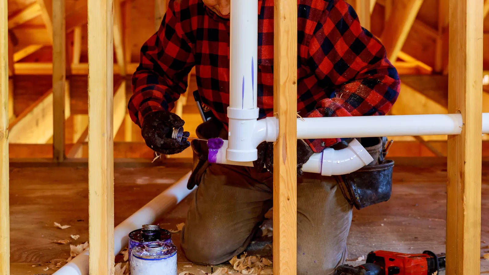 Plumber assembling pipe during commercial construction installation